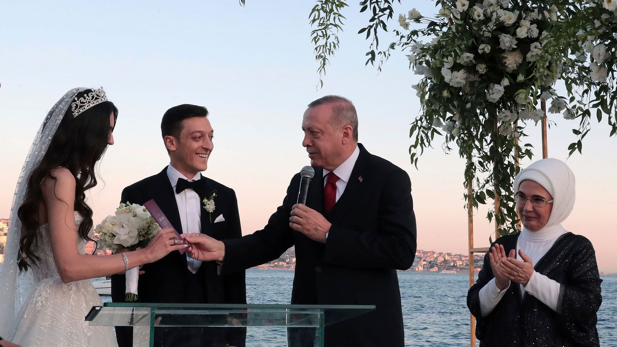 Turkey’s President Recep Tayyip Erdogan speaks to Turkish-German soccer player Mesut Ozil and his wife Amine Gulse during a wedding ceremony.