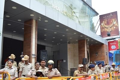 Bengaluru: Police personnel deployed outside the showroom of IMA Jewels on Lady Curzon Road where investors protest demanding their money back after a message about the death of the Group