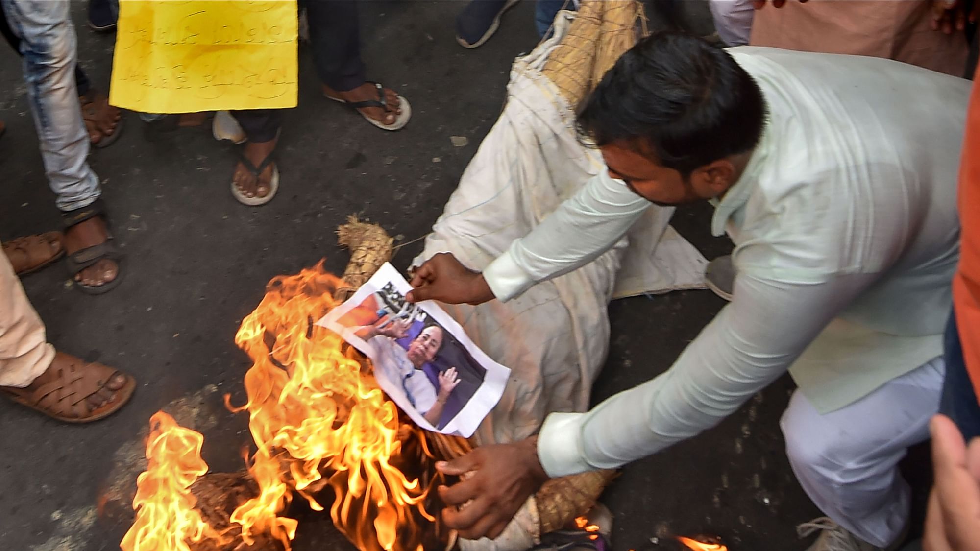 BJP workers burn a photograph of Chief Minister Mamata Banerjee during a protest against alleged failure of law and order situation, and killing of the party workers in the various districts of West Bengal, in Kolkata, Sunday.