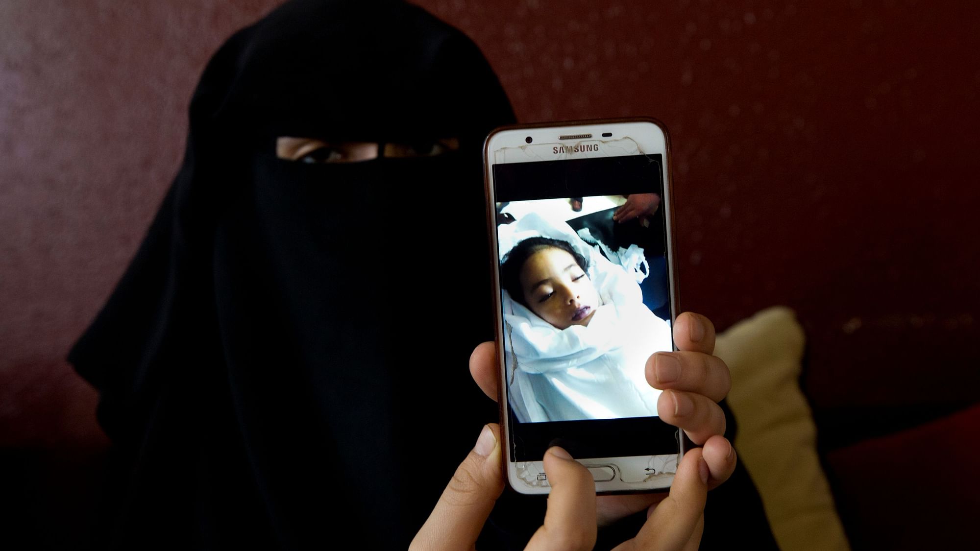  Muna Awad, mother of 5-year-old Aisha a-Lulu, shows a photo of her daughter while Aisha is in a Jerusalem hospital, at the family home in Burij refugee camp, central Gaza Strip.&nbsp;