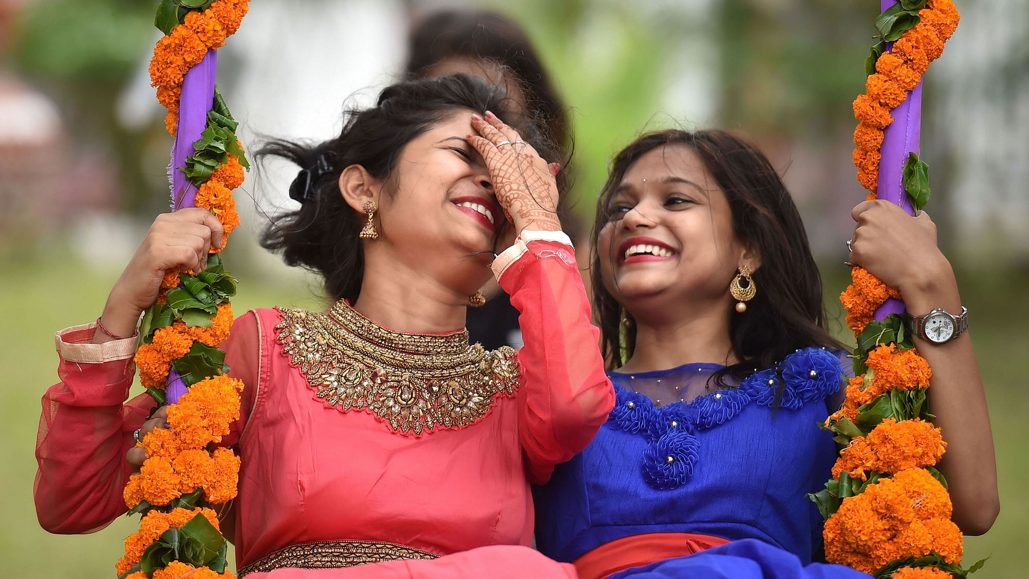 Girls enjoy on a swing on the 1st day of Raja festival celebrating womanhood in Bhubaneswar, Odisha, Thursday, 13  June.