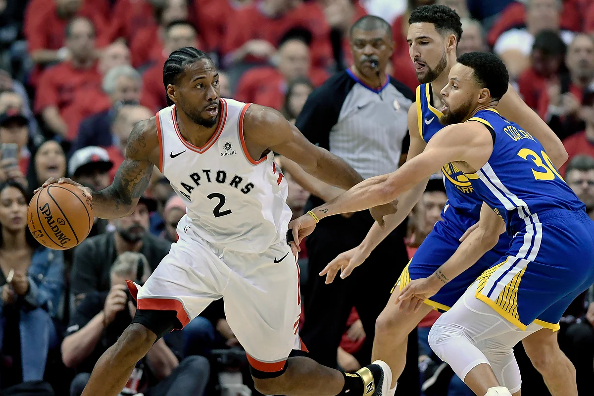 Toronto Raptors forward Kawhi Leonard (2) looks for a way out under pressure from Golden State Warriors guard Stephen Curry (30) and teammate Klay Thompson (11).