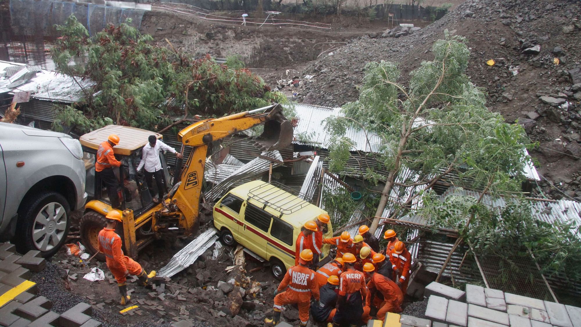 Rescue team at the site where a portion of the compound wall of a housing society collapsed on shanties adjacent to it in Kondhwa area, in Pune, Saturday, 29 June.