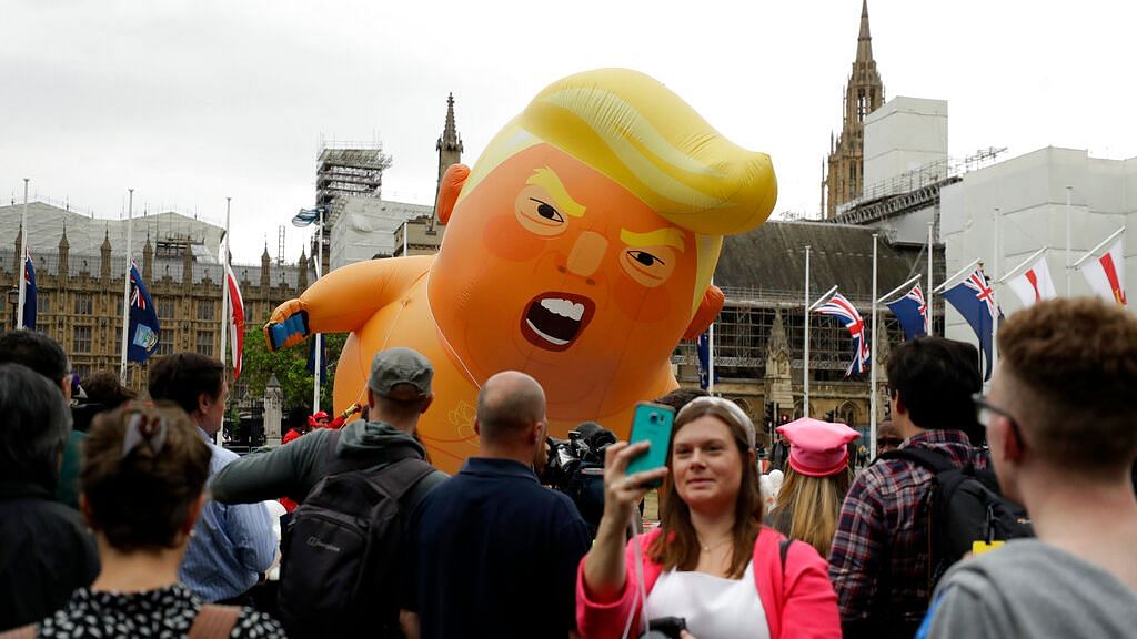 A woman takes a selfie as the ‘Trump Baby’ blimp is inflated in Parliament Square in central London as people start to gather to demonstrate against the state visit of President Donald Trump on Tuesday, 4 June, 2019.