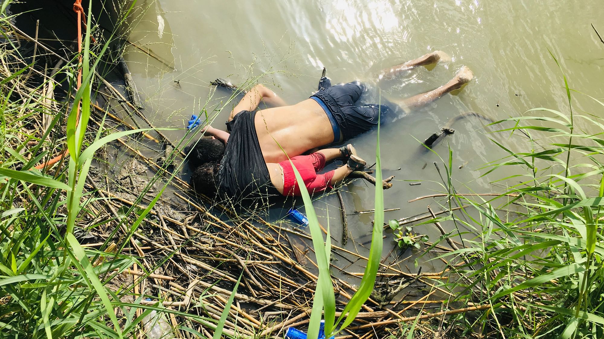 The bodies of two Salvadoran migrants lie on the bank of the Rio Grande in Matamoros after they drowned trying to cross a river.