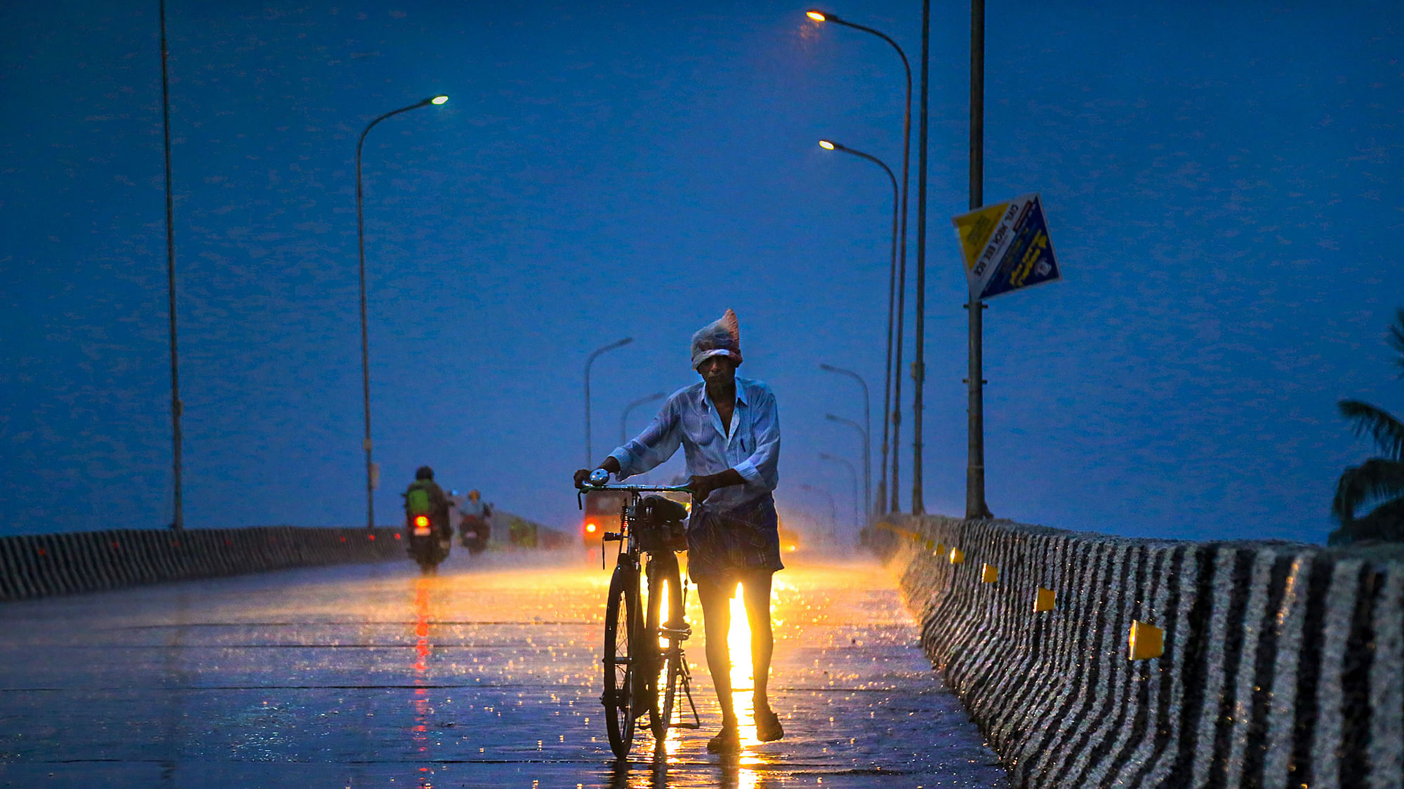 File Photo: A man walks along a road with his bicycle during pre-Monsoon showers at Nagercoil in Kanyakumari district on 10 June 2019.&nbsp;
