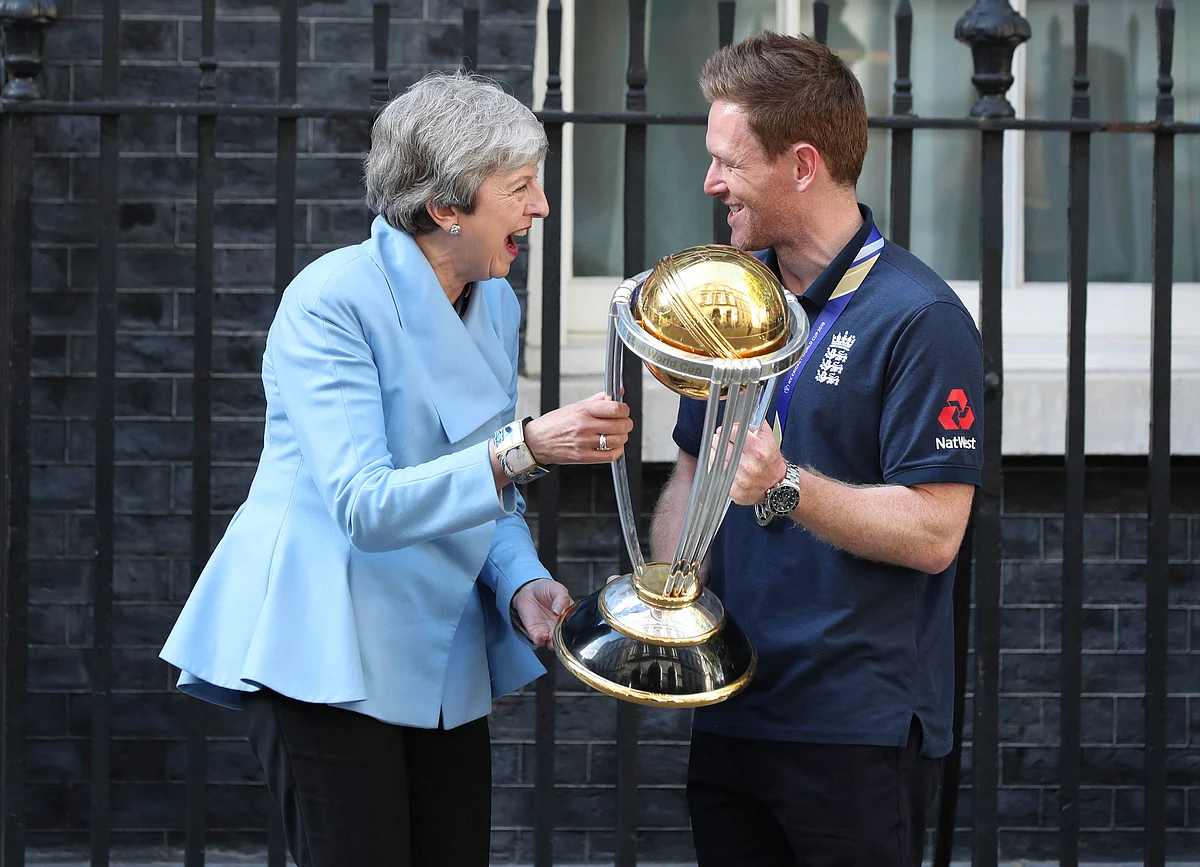 Britain’s Prime Minister Theresa May laughs with England cricket captain Eoin Morgan and the trophy after England won the Cricket World Cup.