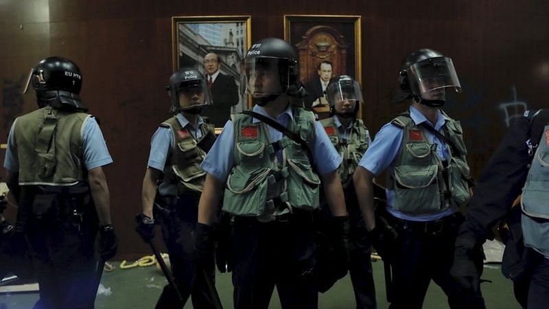 Police officers with protective gear retake the meeting hall of the Legislative Council in Hong Kong, during the early hours of Tuesday