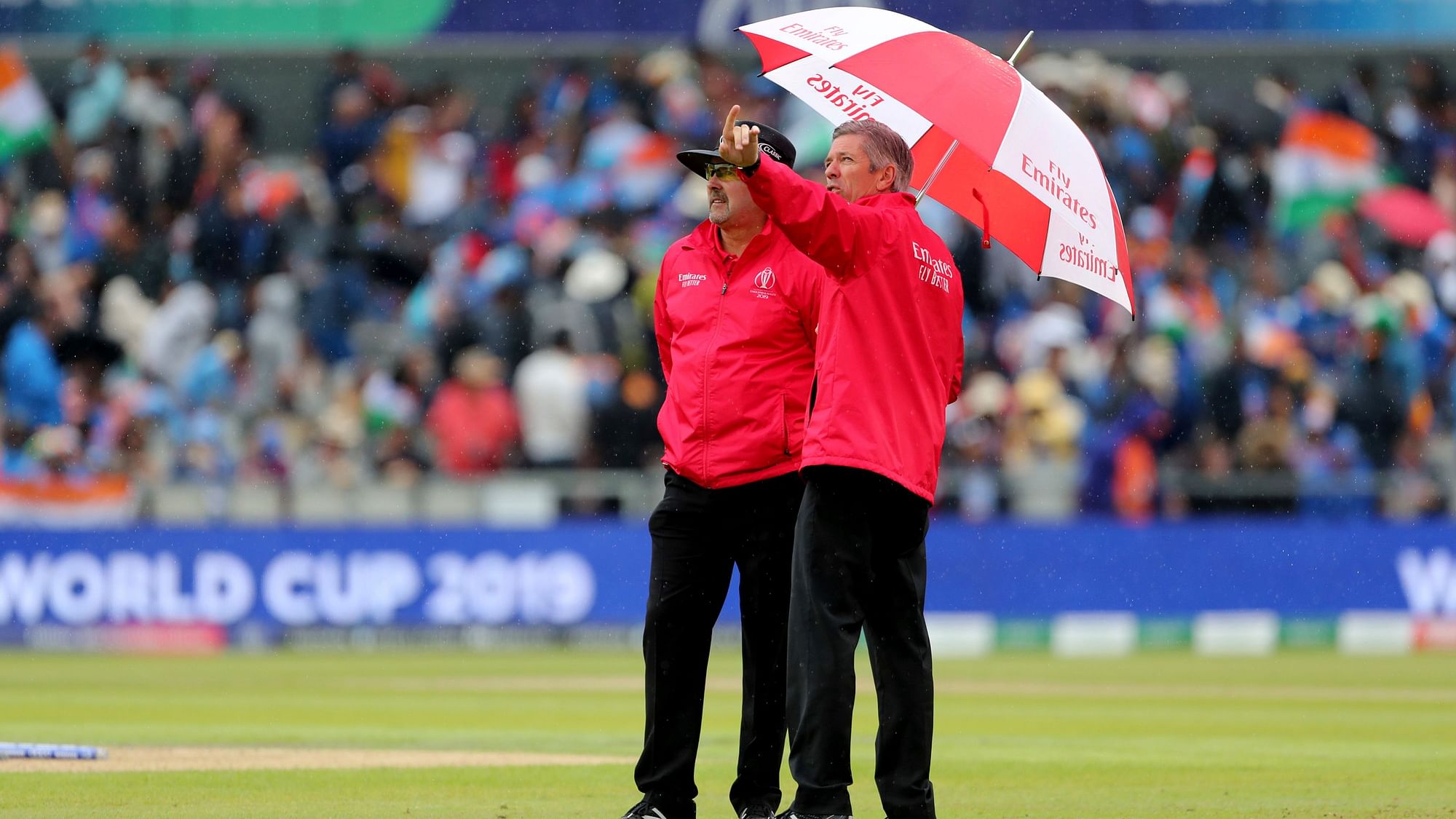 Umpires interact after rain stopped play during the Cricket World Cup semi-final match between India and New Zealand at Old Trafford in Manchester.