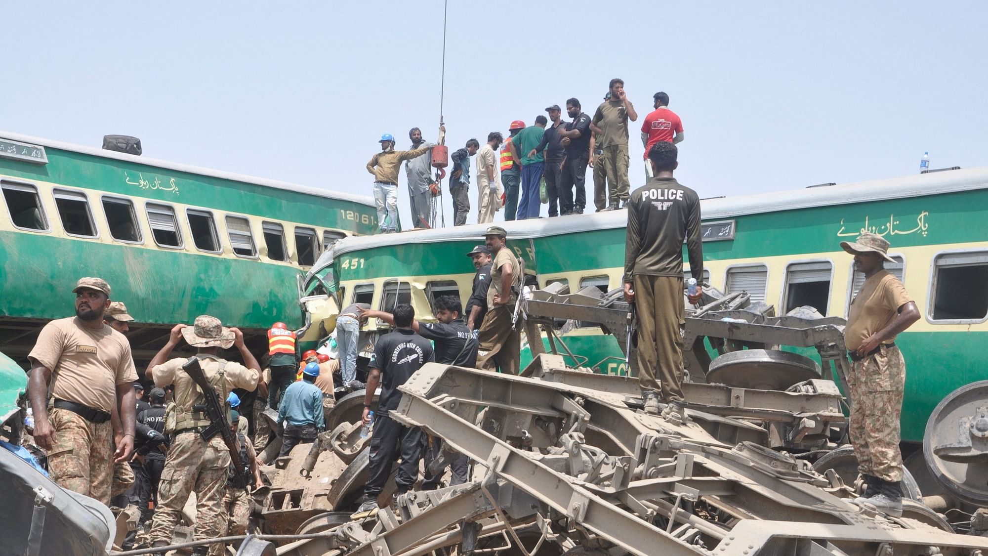 Pakistani officials and volunteers work at a train crash site in Rahim Yar Khan, Pakistan, on 11 July 2019.