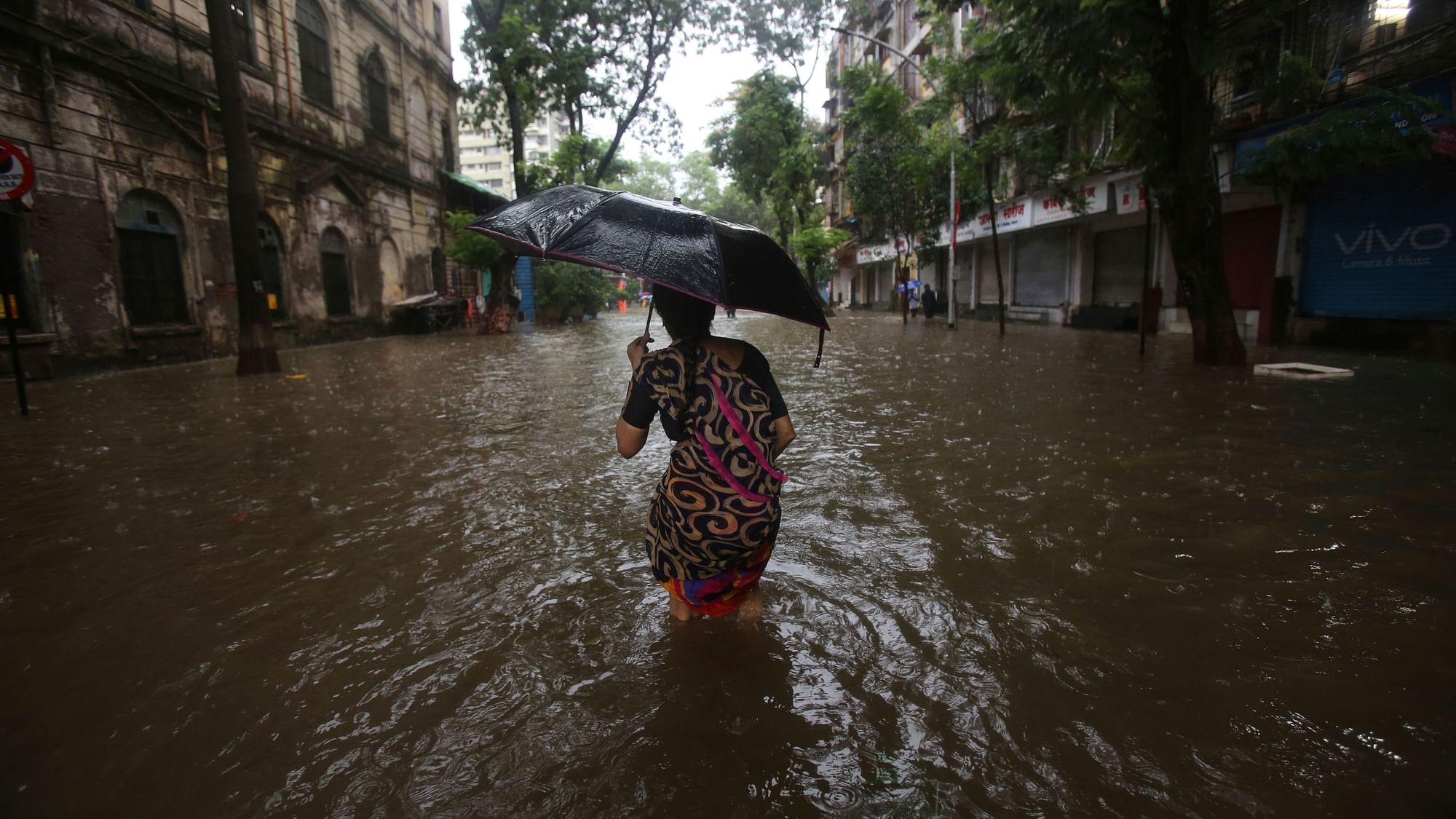 A woman walks in the middle of a waterlogged street in Mumbai.