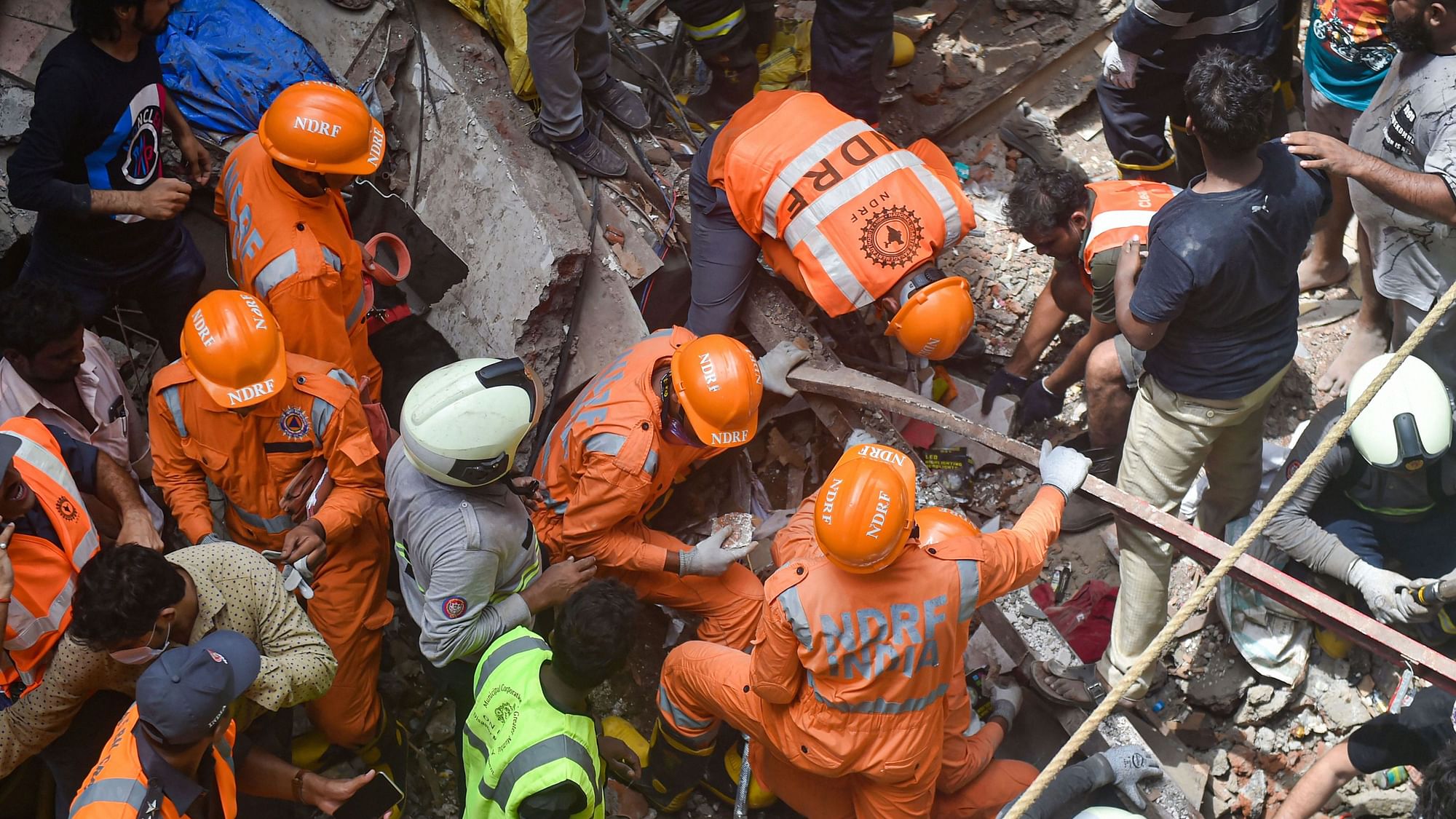 Fire Brigade and NDRF personnel carry out rescue works after the collapse of the four-storey Kesarbai building at Dongri in Mumbai on 16 July 2019. &nbsp;