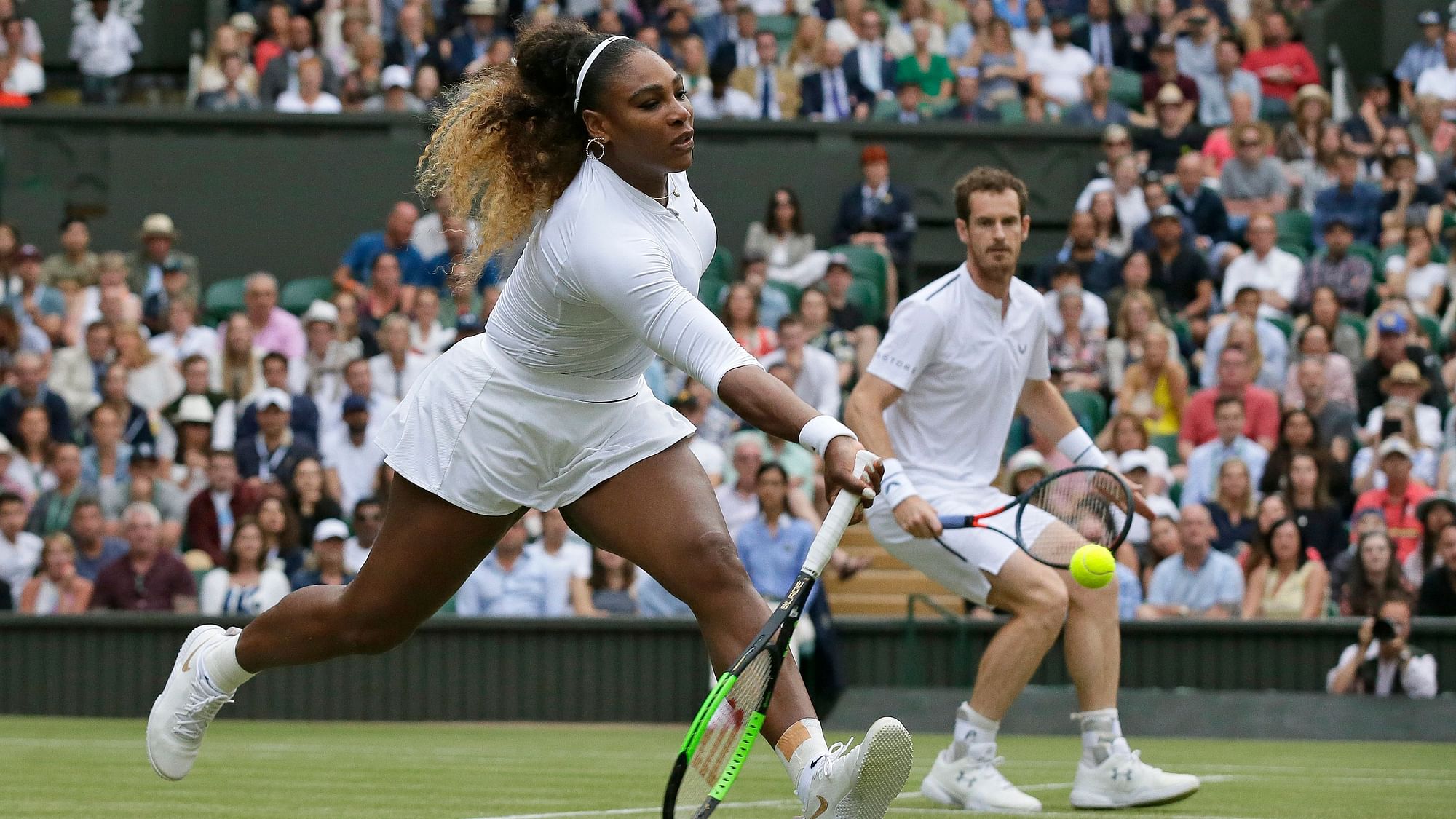 United States’ Serena Williams, left, is watched by playing partner Andy Murray as she plays a shot during a mixed doubles match at Wimbledon.