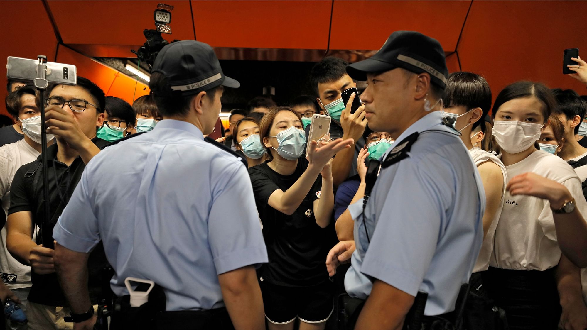 Two Police officers are surrounded by protesters at a subway platform in Hong Kong Tuesday, July 30, 2019. 