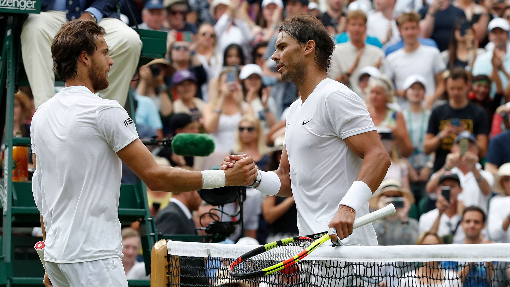  Rafael Nadal (R), greets Joao Sousa at the net after beating him in a Men’s singles match at the Wimbledon Tennis Championships.
