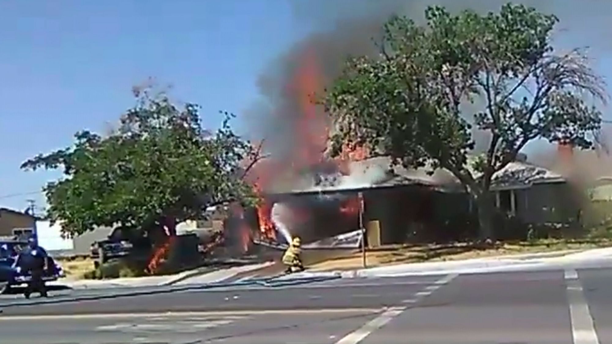 In this image taken from video provided by Ben Hood, a firefighter works to extinguish a fire, Thursday, 4 July.