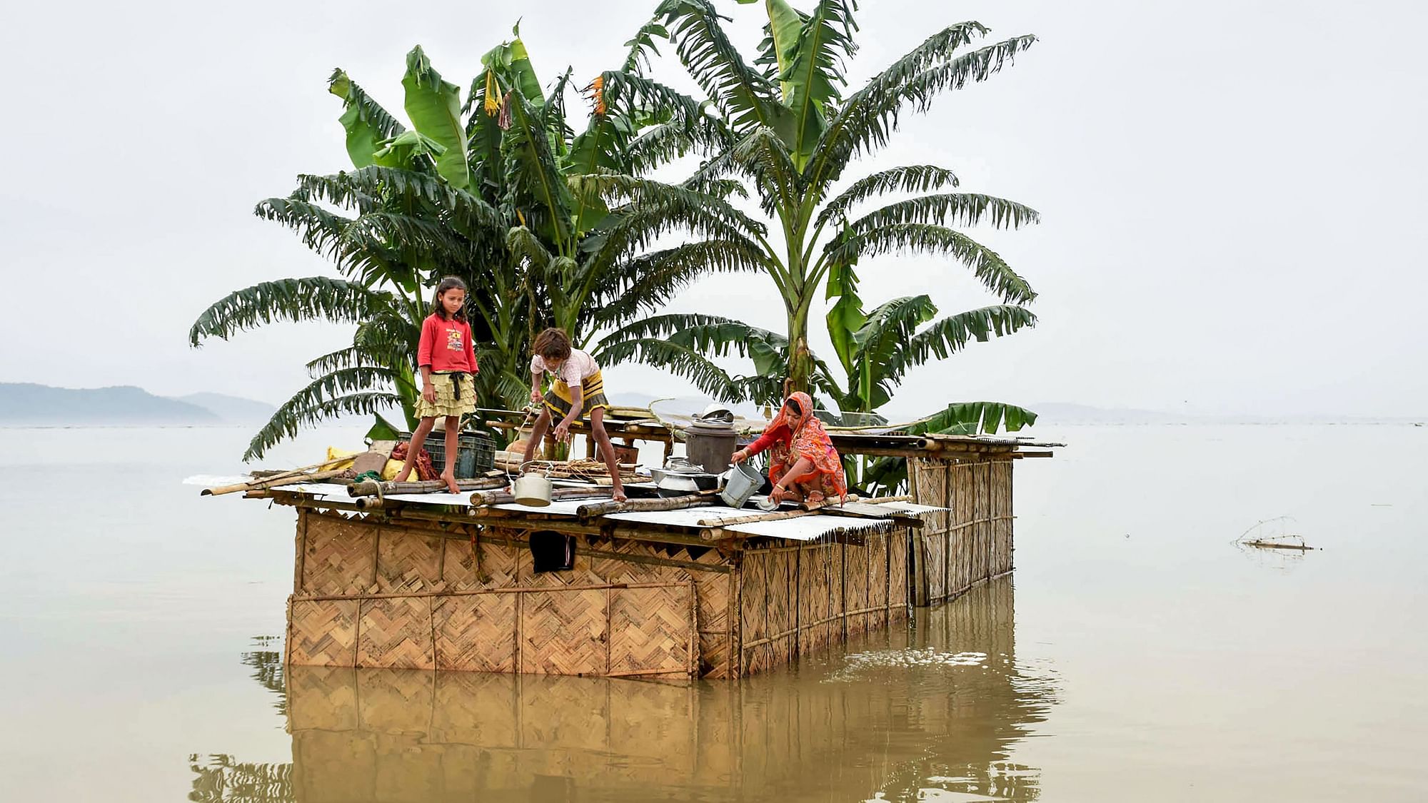 A family marooned on the top of a hut in the flood-hit locality of Panikhaiti in Kamrup, Asssam on 15 July.