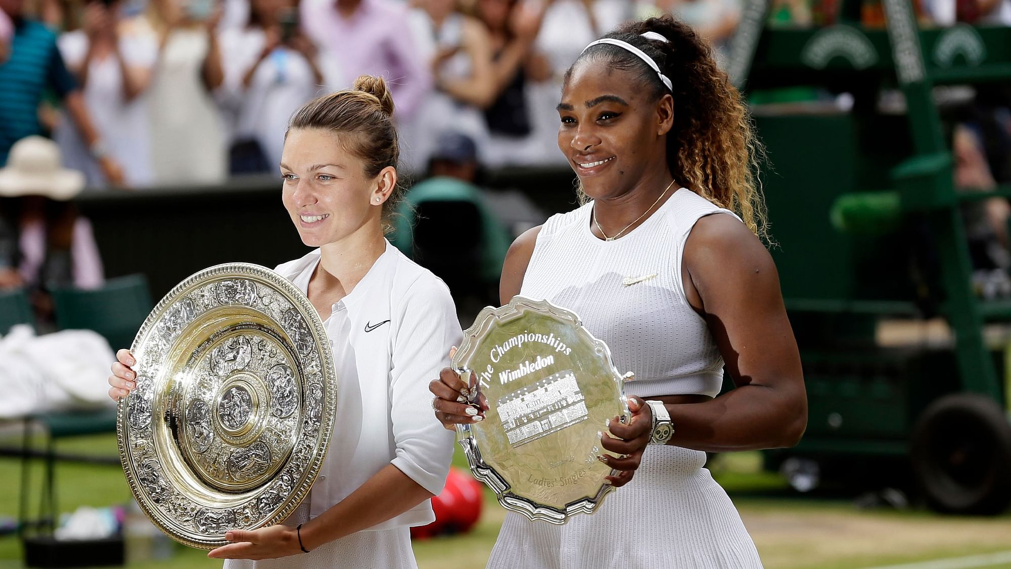 Winner Romania’s Simona Halep and second placed United States’ Serena Williams, right, pose with their trophies after the women’s singles final match on day twelve of the Wimbledon Tennis Championships in London.