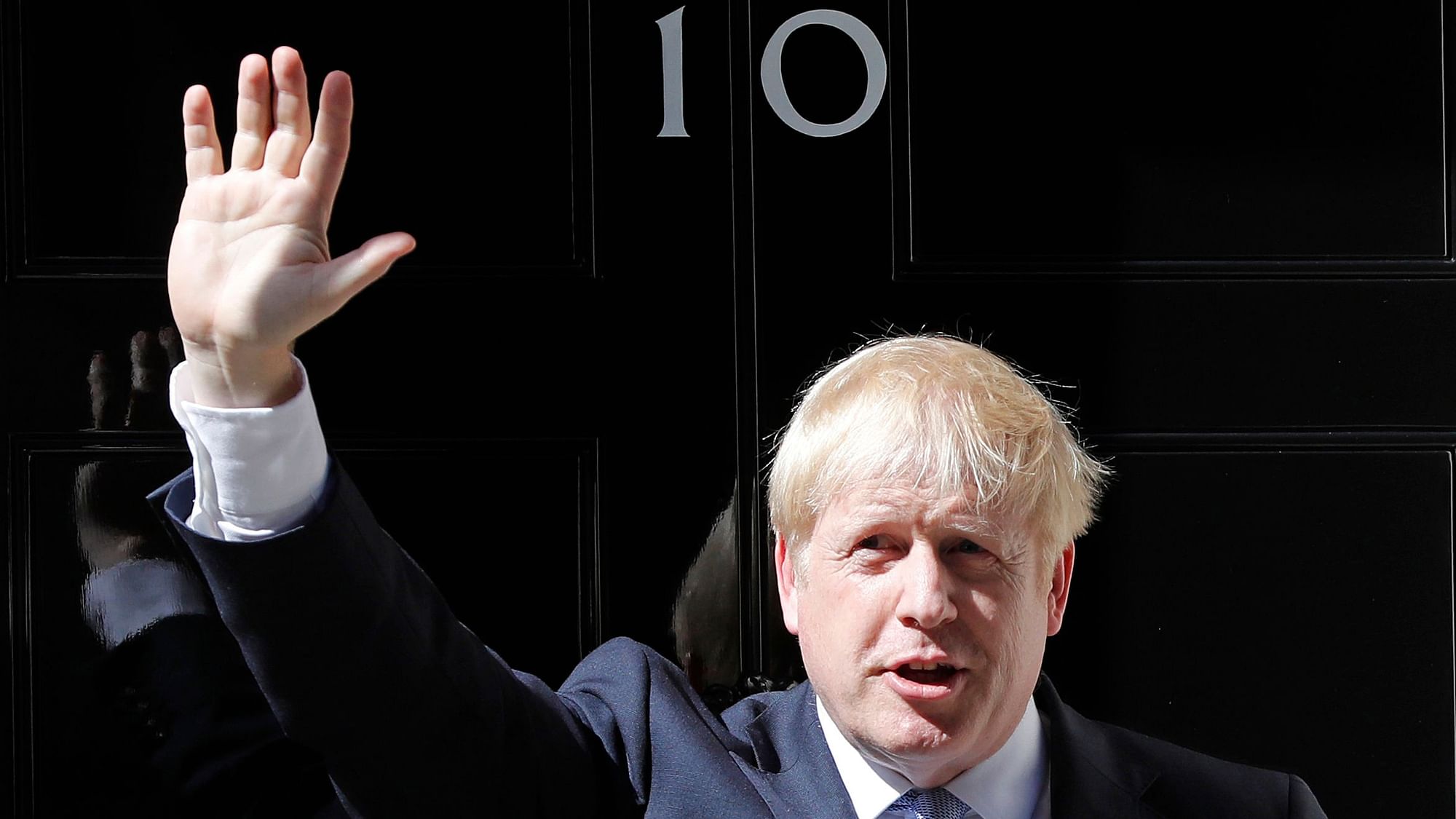 Britain’s new Prime Minister Boris Johnson waves from the steps outside 10 Downing Street, London.