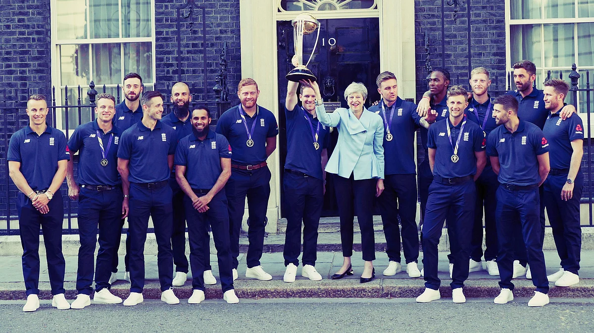 Britain’s Prime Minister Theresa May smiles as she stands with England cricket captain Eoin Morgan and members of the team.