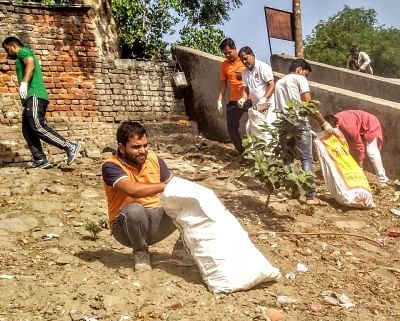 New Delhi: Newspaper hawkers clean the Yamuna river at Yamuna Chhath Ghat near ITO in Delhi. (Photo: IANS)