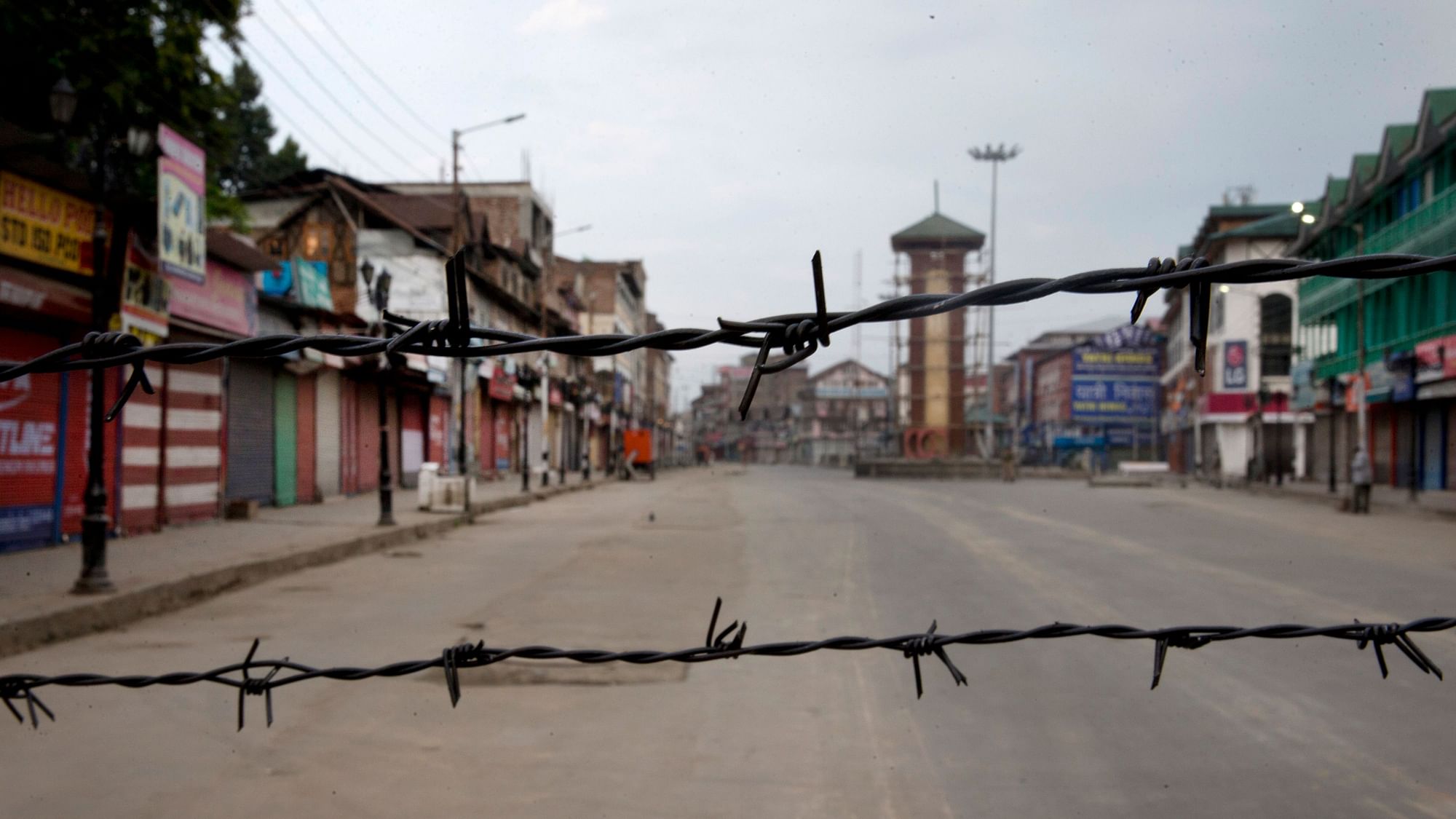 A deserted street seen through a barbwire set up as blockade during curfew in Srinagar, Kashmir