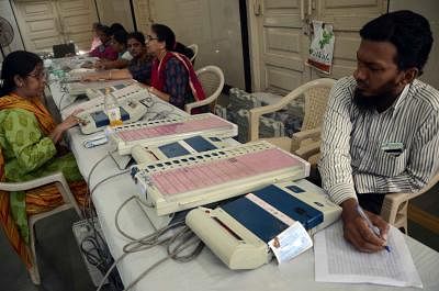 Polling personnel inspect Electronic Voting Machines ahead of Maharashtra Assembly polls in Mumbai, on Oct.8, 2014. (Photo: Sandeep Mahankal/IANS)
