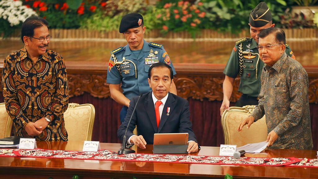 Indonesia President Joko Widodo, center, takes his seat before a press conference, at the palace in Jakarta on 26 August 2019. &nbsp;