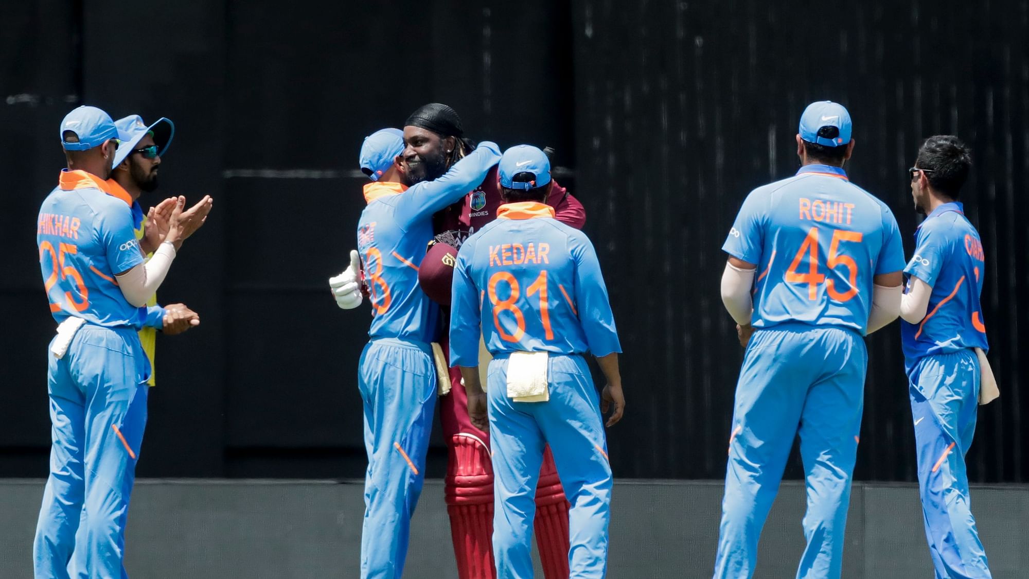 West Indies opening batsman Chris Gayle, fourth left, is congratulated by India captain Virat Kohli, third left, after Gayle was caught out by Kohli for 72 runs during their third One-Day International cricket match in Port of Spain, Trinidad, Wednesday, Aug. 14, 2019.