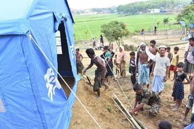 DHAKA, Oct. 4, 2017 (Xinhua) -- An Army personnel helps a Rohingya family to set up Chinese relief tent at a camp in Cox