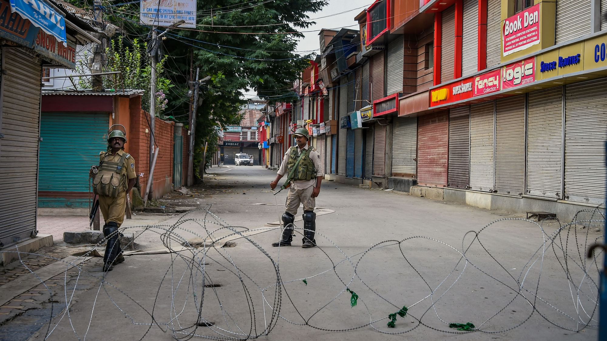 Security personnel stand guard during restrictions in Srinagar on 12 August.&nbsp;