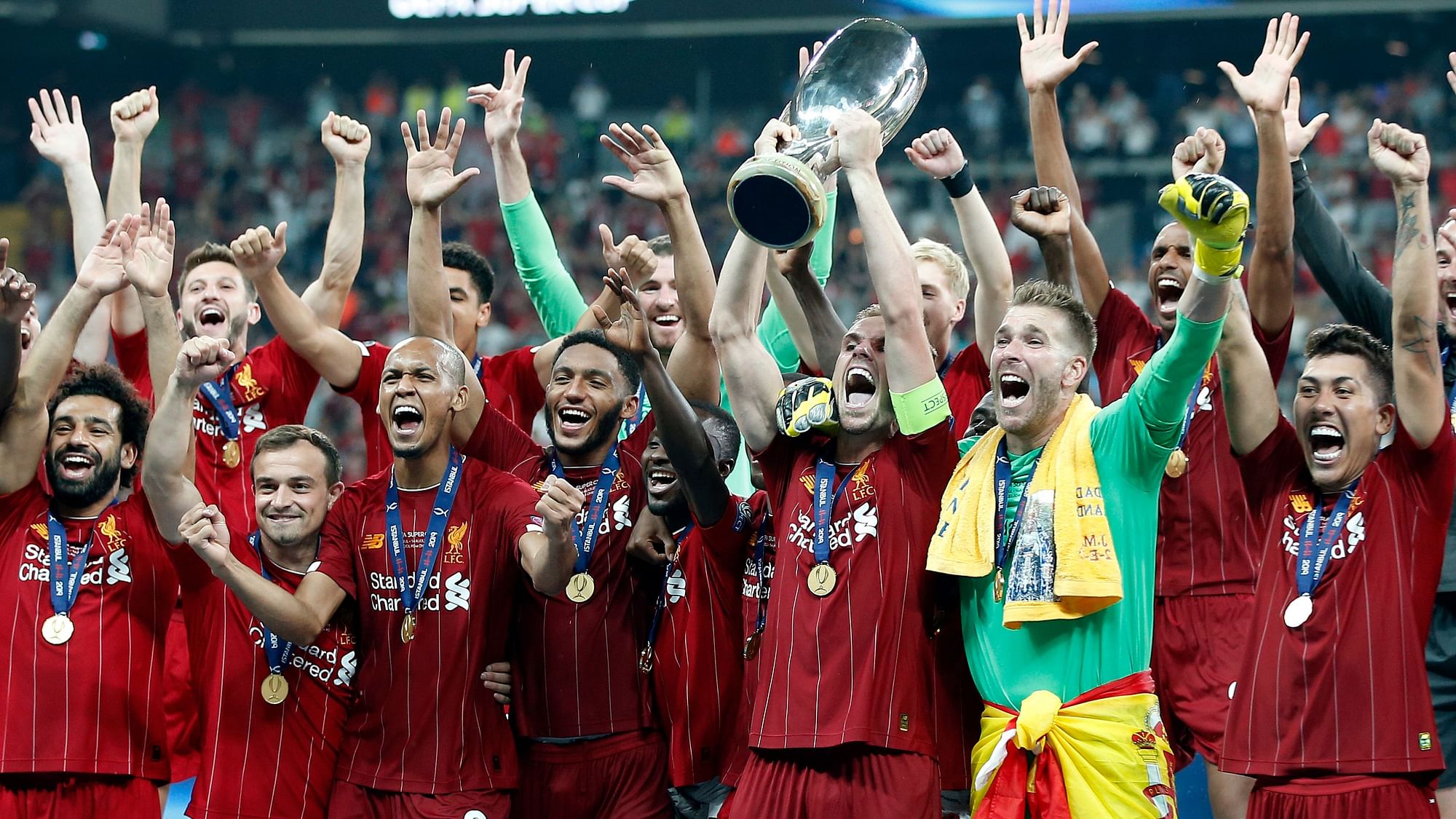 Liverpool’s Jordan Henderson raises the trophy to celebrate with teammates after winning the UEFA Super Cup soccer match between Liverpool and Chelsea, in Besiktas Park, in Istanbul, Wednesday, Aug. 14, 2019.