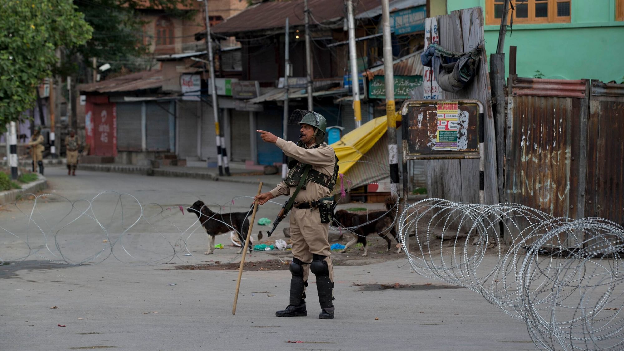 An Indian paramilitary soldier gestures towards a Kashmiri man as he orders him to turn back during lockdown in Srinagar on Sunday, 18 August.