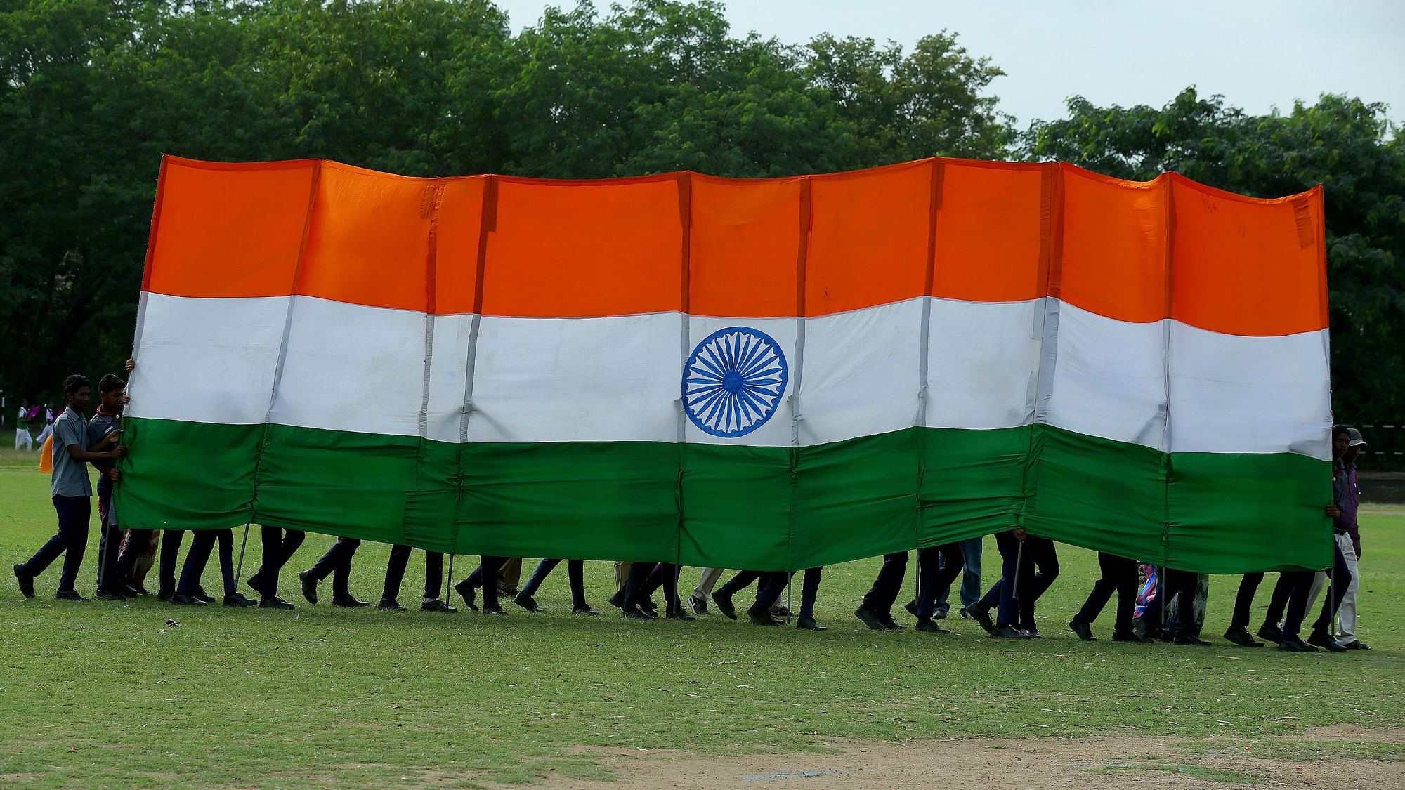 Students hold a huge Indian flag as they perform a dance during the Independence Day celebrations in Hyderabad, India, Thursday.