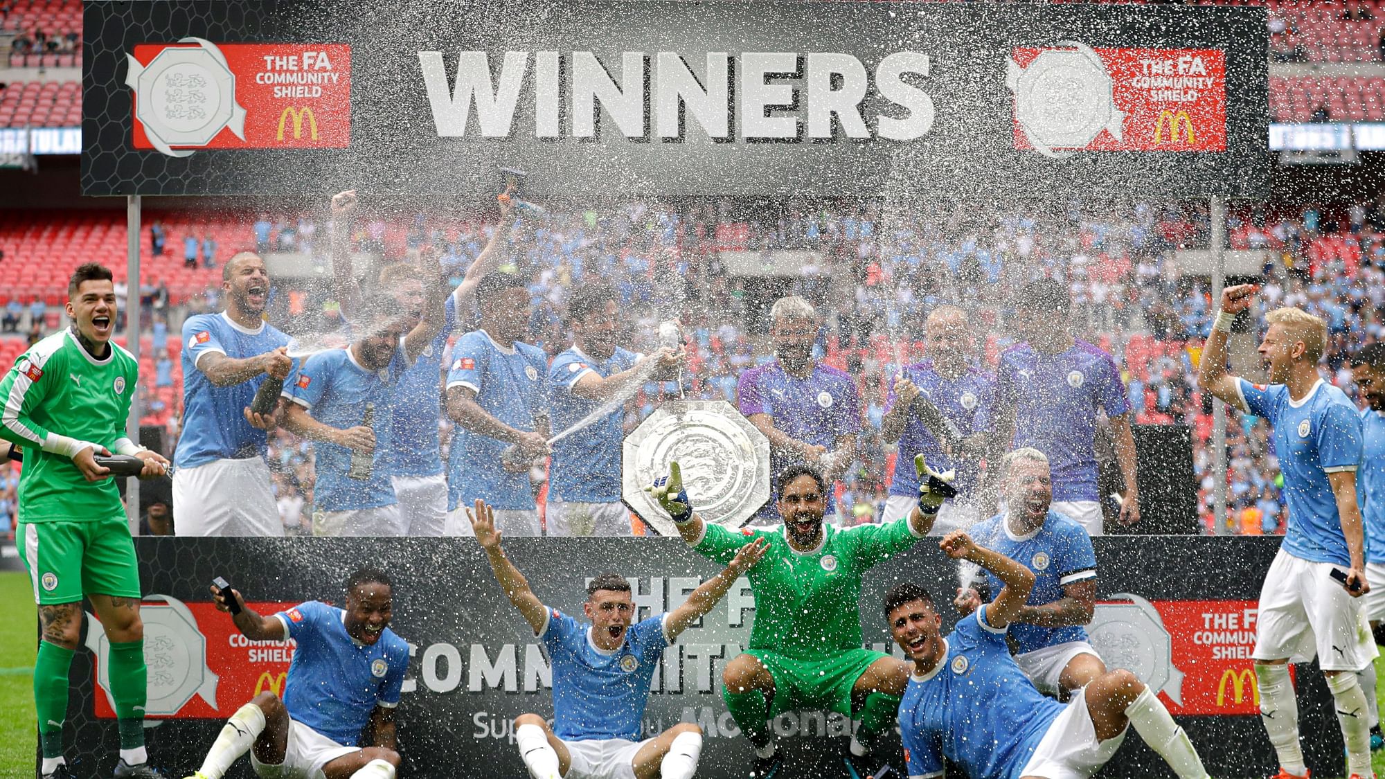 Manchester City’s players celebrate with the trophy after the English Community Shield soccer match between Liverpool and Manchester City at Wembley stadium in London.