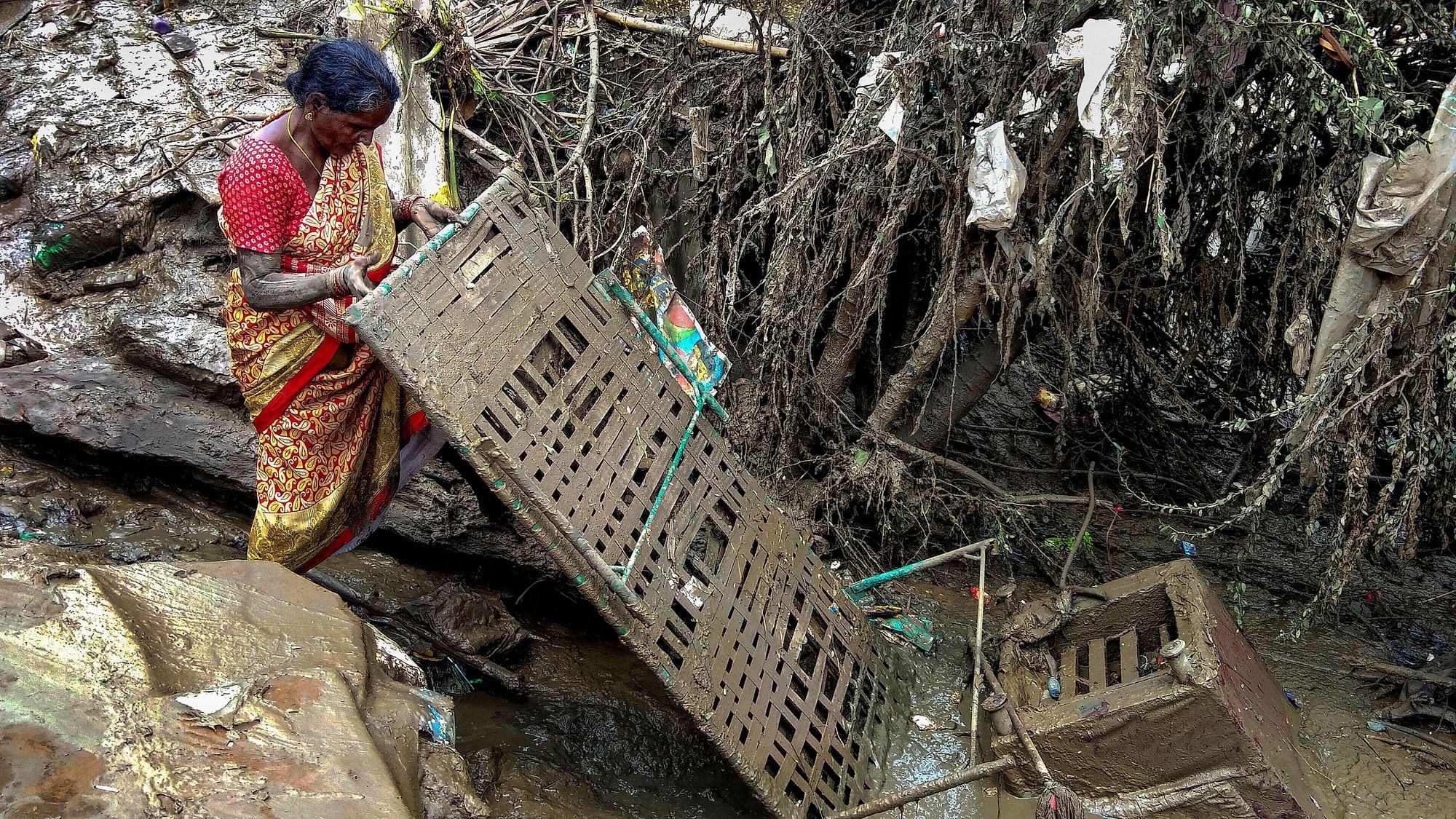 A woman salvages her household items after flood water receded from her house. Image used for representation.