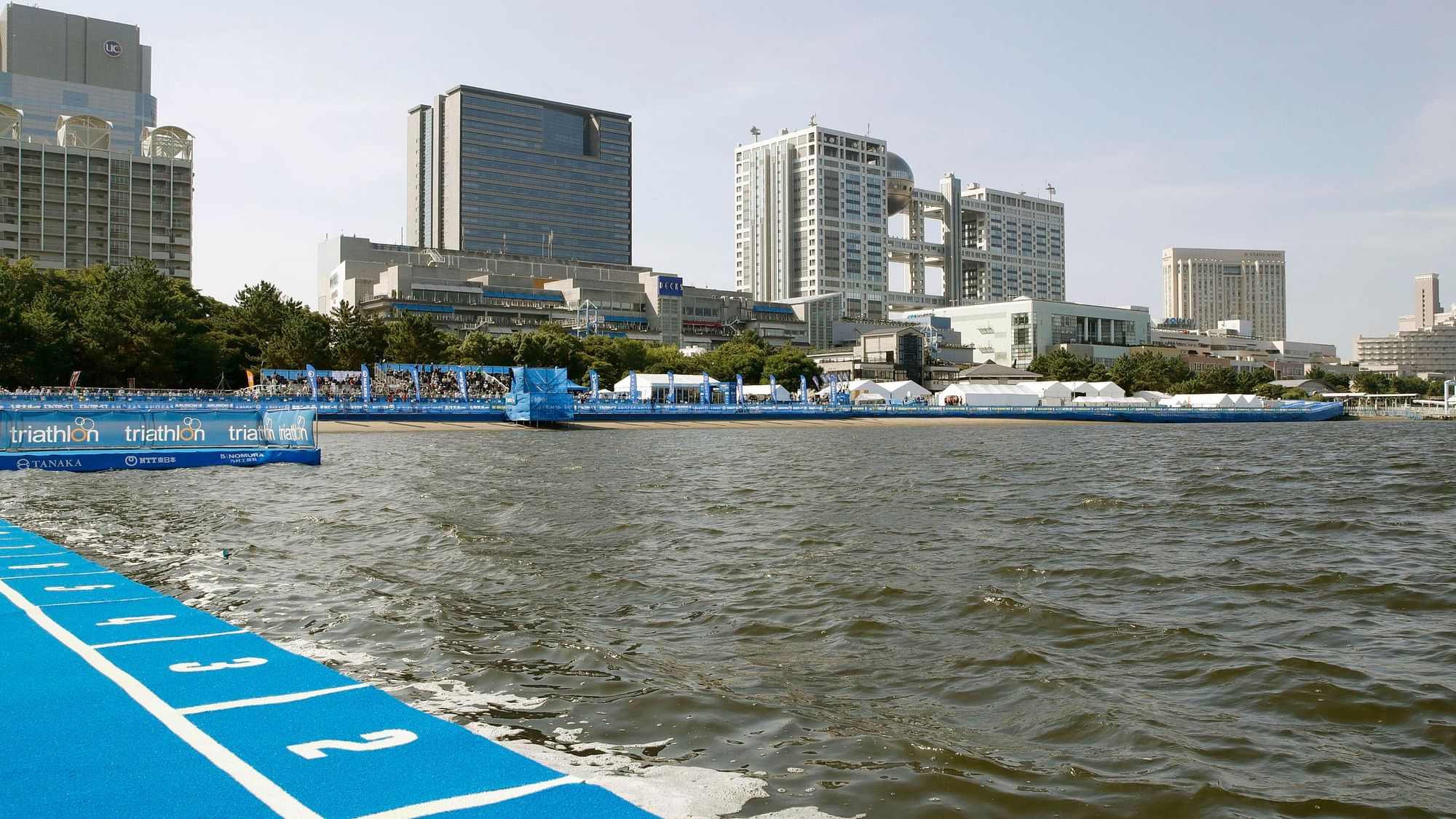 Competitors at a marathon swimming test event on Sunday complained of smelly water and high-water temperature at Odaiba Bay.