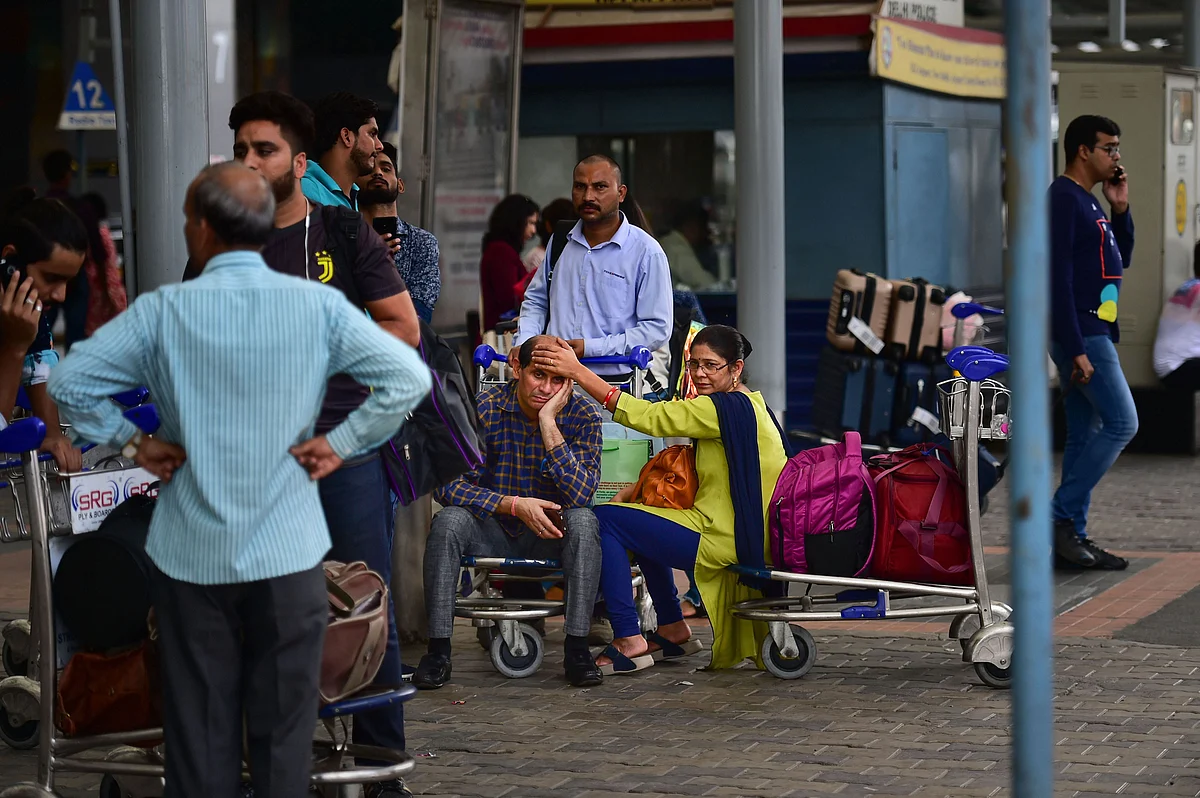 Passengers wait for a taxi with their luggage outside Delhi Airport during the transport strike, in New Delhi on Thursday, 19 September. Commuters faced difficulties in reaching their destinations as several private buses, taxis and auto-rickshaws remained off the roads due to a strike called by the UFTA against the amended Motor Vehicle Act provisions. 