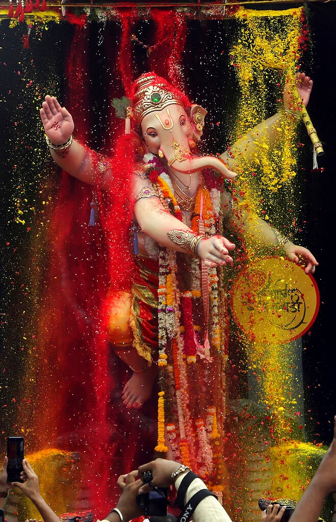 People take photographs of a giant idol of elephant-headed Hindu god Ganesha as it is taken for immersion on the tenth day of the ten-day long Ganesh Chaturthi festival in Mumbai. The festival is a celebration of the birth of Ganesha, the Hindu god of wisdom, prosperity and good fortune.