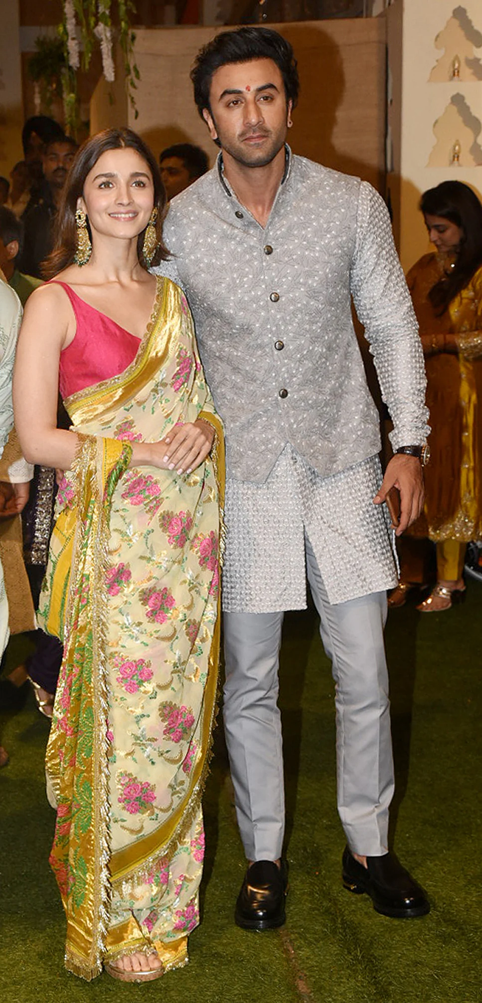 While Alia Bhatt rocks a printed saree, Ranbir Kapoor looks dashing in a silver kurta paired with a jacket.
