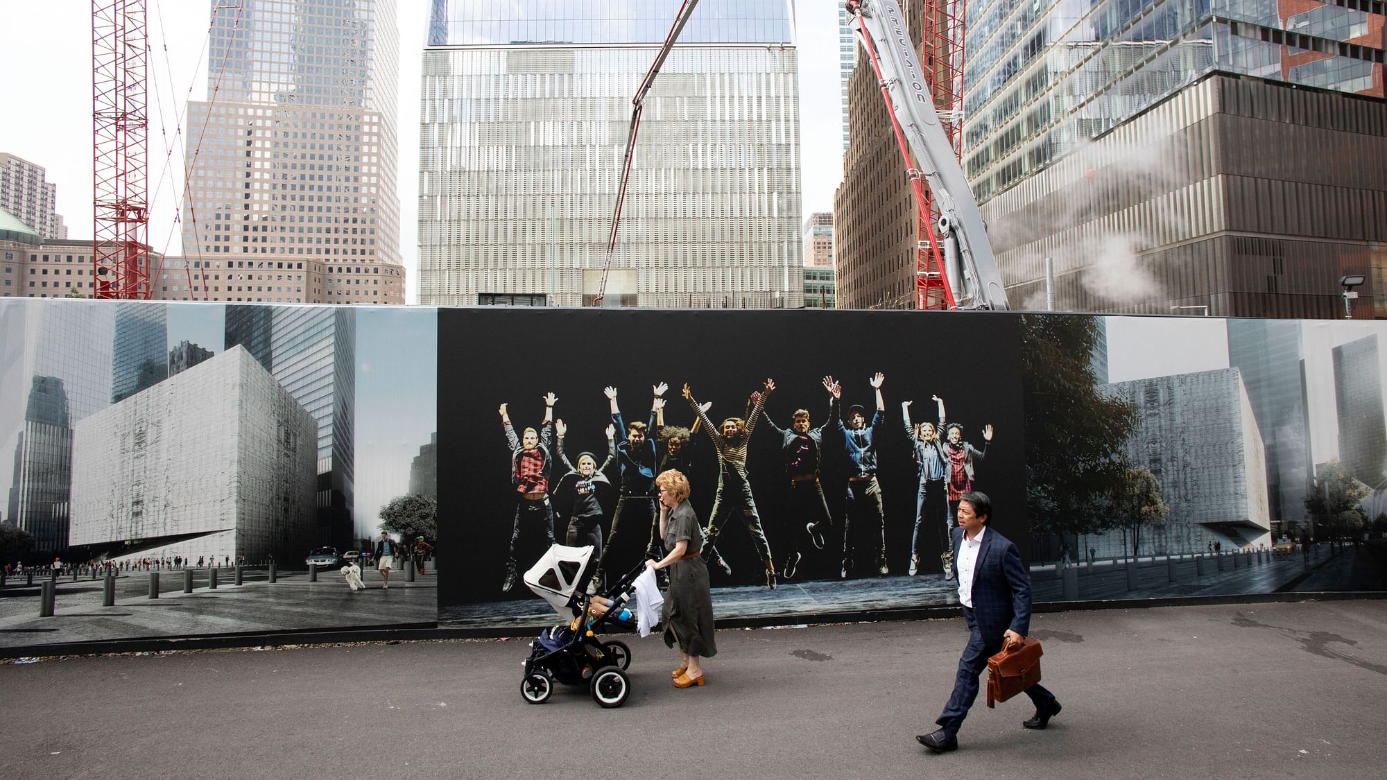 People walk by murals promoting the future site of the Ronald O. Perelman Performing Arts Center.
