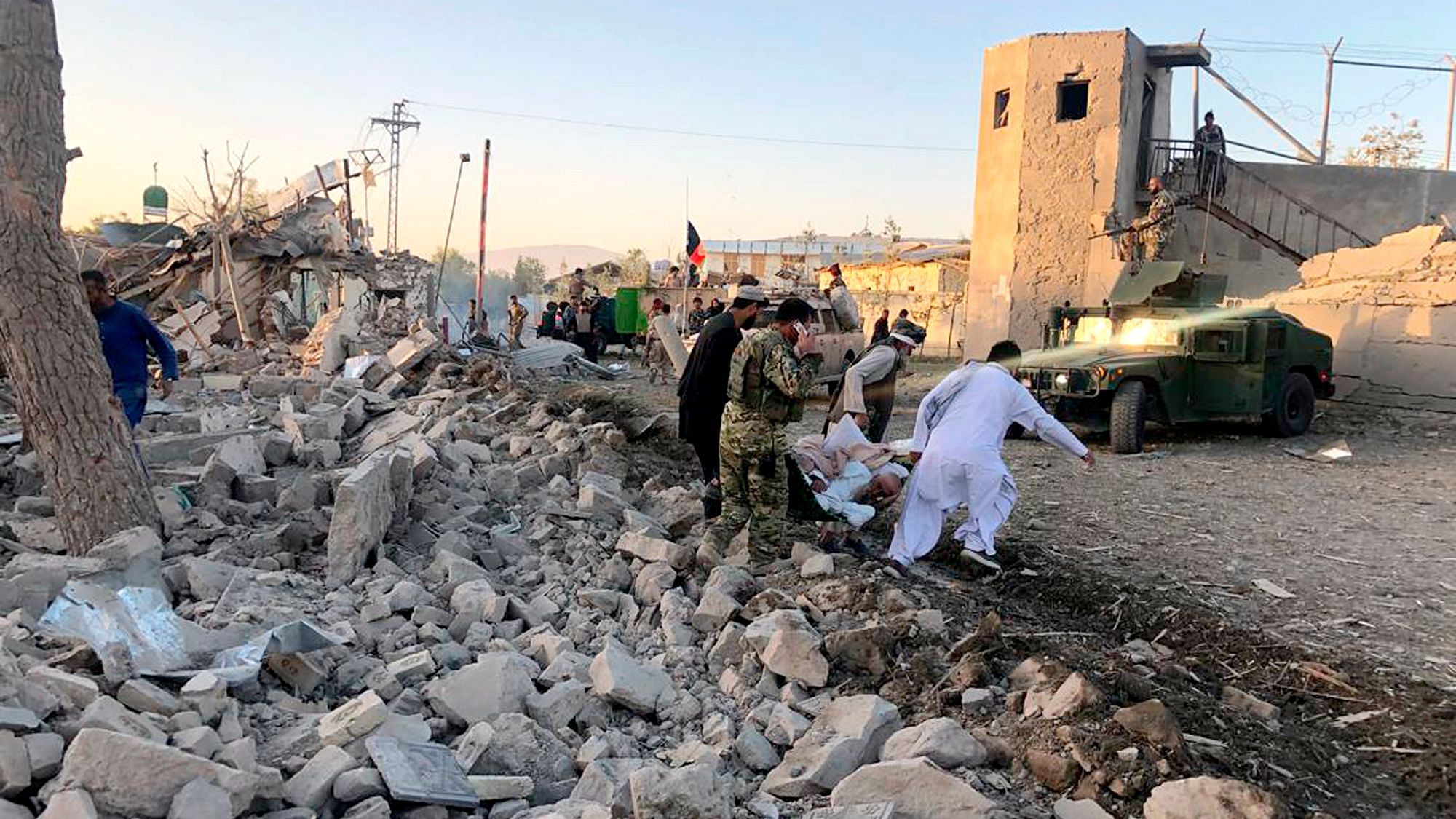 Afghan security members and people engage in rescue work at the site of the blast.