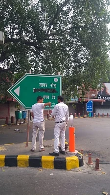 New Delhi: Hindu Sena activists blacken the signage for Babar Road at Bengali market demanding that it be renamed after a "great Indian personality"., in New Delhi on Sep 14, 2019. (Photo: IANS)