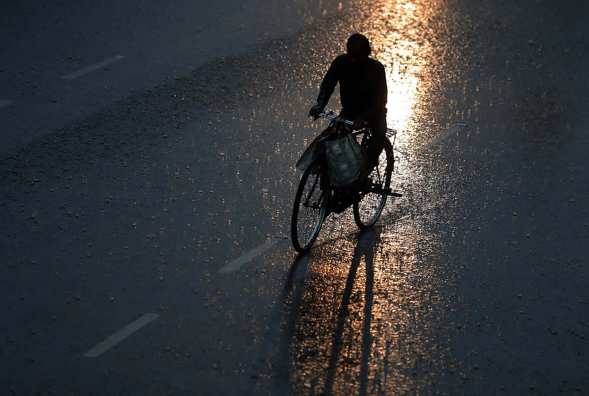 An Indian man rides a bicycle in the rain in Hyderabad, Tuesday, 24 September.