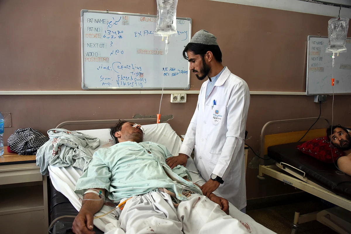 Wounded Afghans lie on a bed at a hospital after a bomb attack on a local mosque in Kandahar province, south of Kabul, Afghanistan.