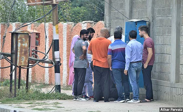 Locals huddle around technicians as they restore landlines in Haiderpura, Srinagar on 7 September 2019.