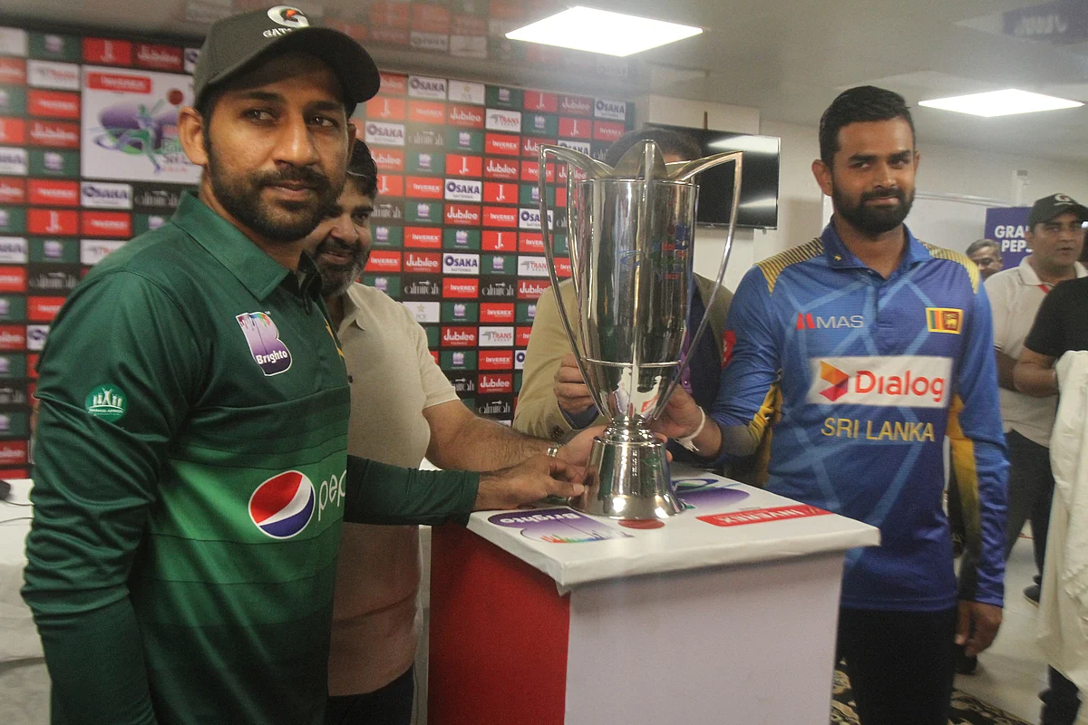 Sri Lanka captain Lahiru Thirimanne, right, and his Pakistani rival Sarfaraz Ahmed stand with a trophy, in Karachi, Pakistan, Thursday, Sept. 26, 2019. 