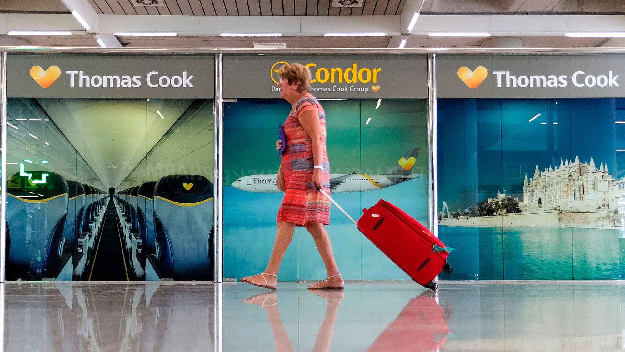 A passenger walks past a closed Thomas Cook office at Palma de Mallorca airport on Monday.