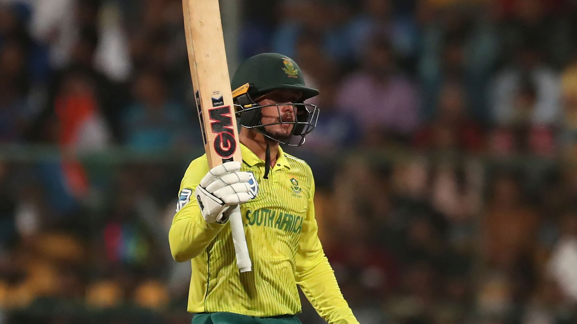 South Africa’s captain Quinton de Kock raises his bat to celebrate scoring fifty runs during the third and last T20 cricket match between India and South Africa in Bengaluru.