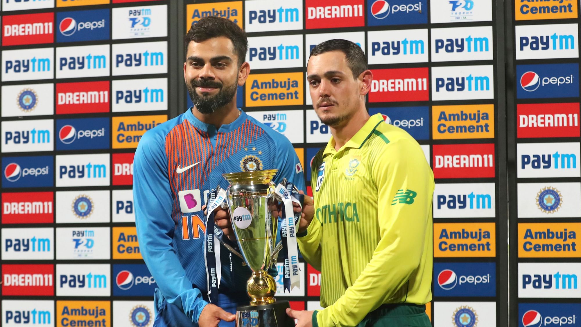 India’s captain Virat Kohli, left, and South Africa’s captain Quinton de Kock hold the winners trophy after it was presented to both of them after the third and last T20 cricket match between India and South Africa .